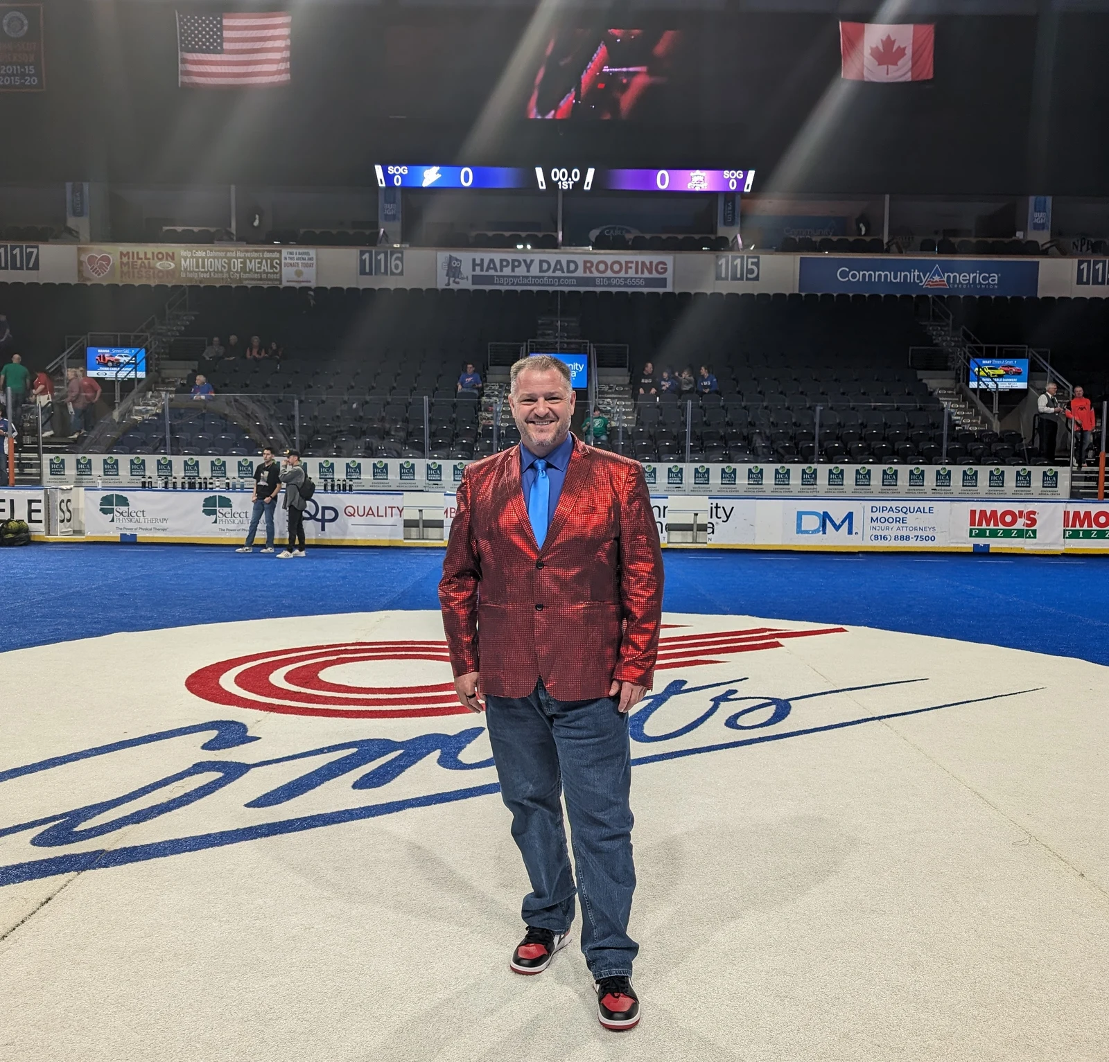 Chris Kamler standing on the ice with a microphone at a hockey arena