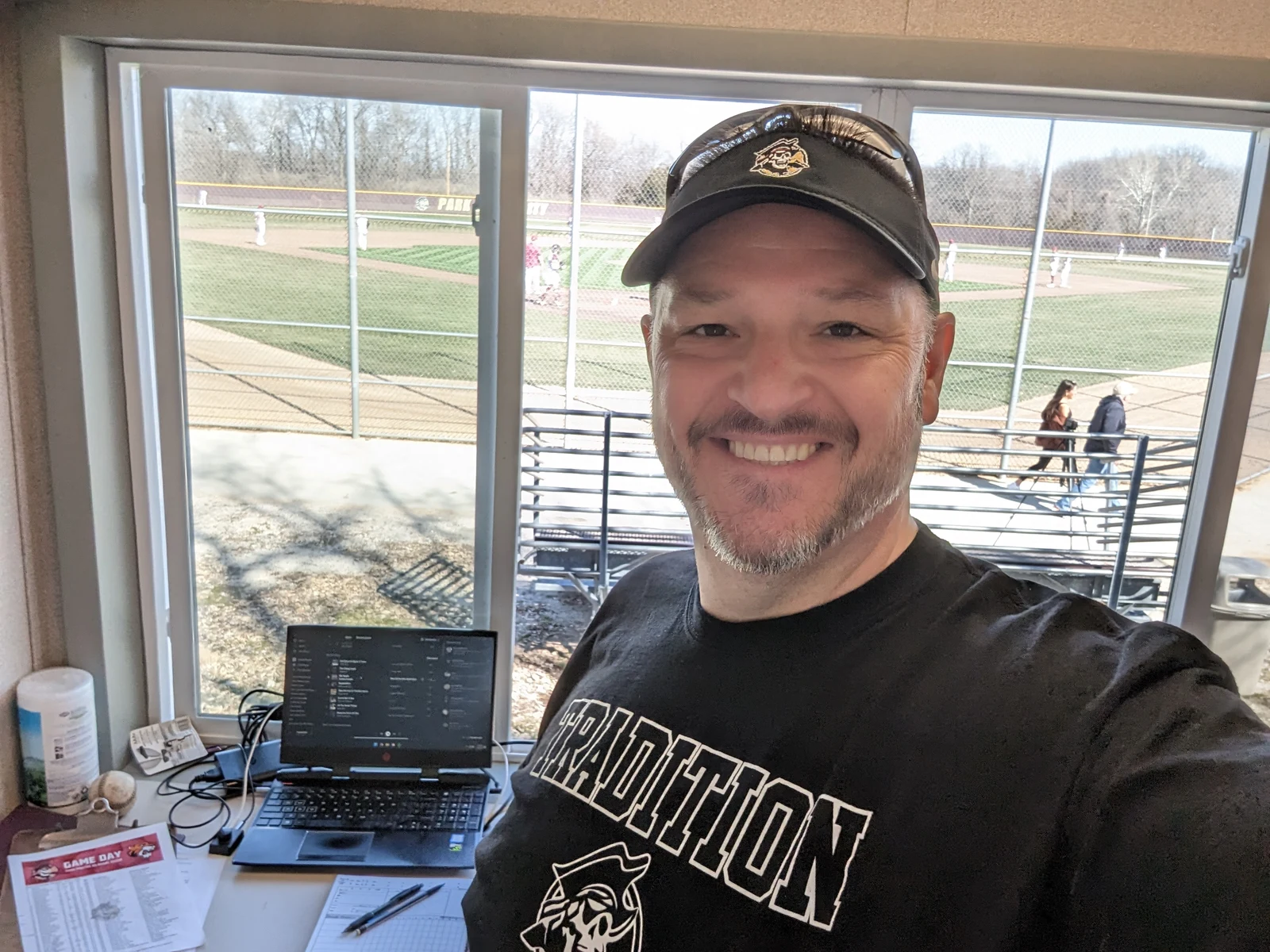 Chris Kamler in an announcing booth overlooking a baseball field