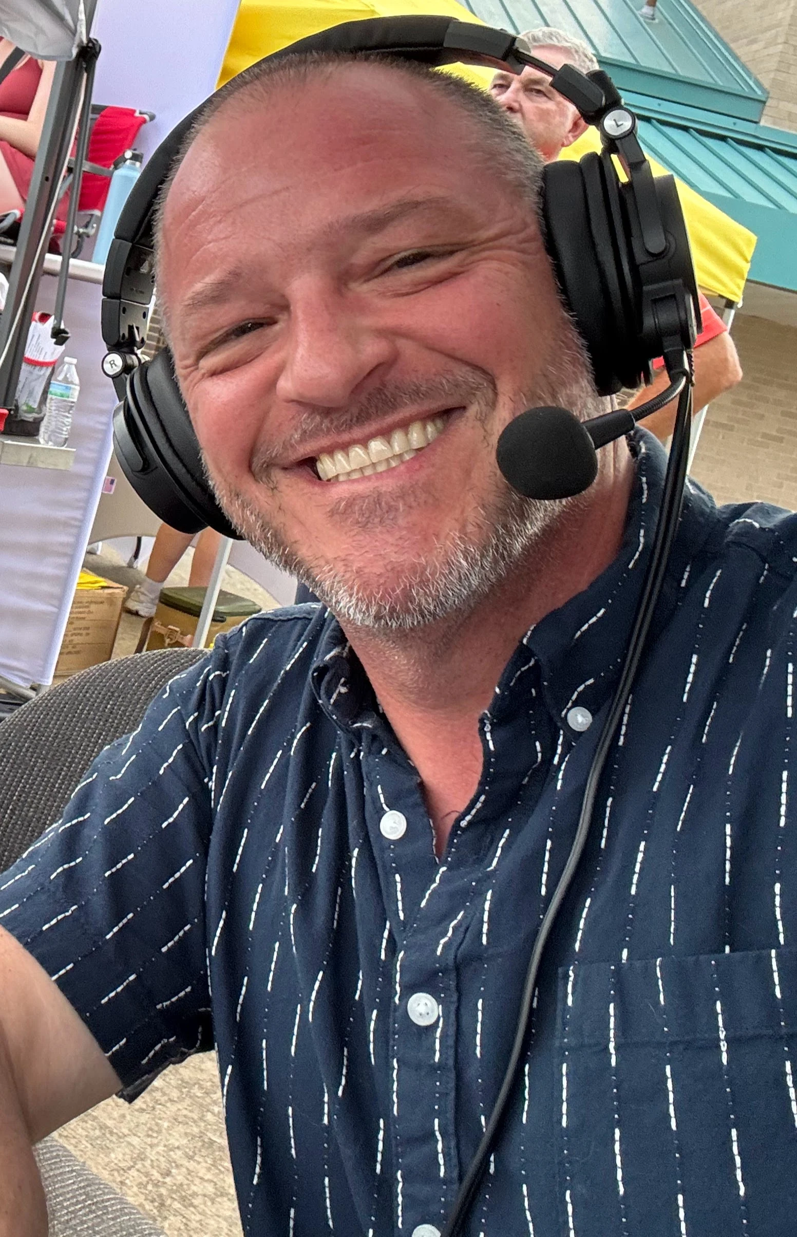 Chris Kamler smiling while wearing a broadcast headset